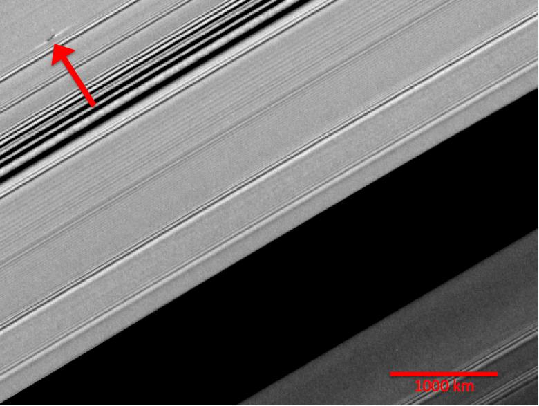 A propeller-shaped structure created by an unseen moon appears dark in this image obtained by NASA’s Cassini spacecraft of the unilluminated side of Saturn's rings.