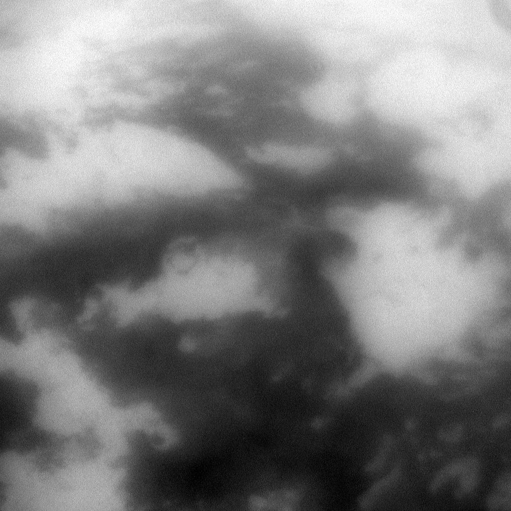 The low albedo feature known as Senkyo is visible through the haze of Titan's atmosphere