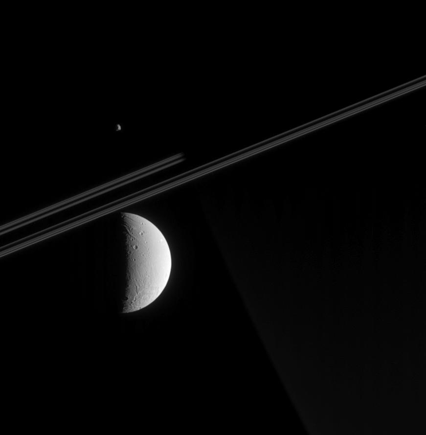 Dione in the foreground and a far-off view of Epimetheus