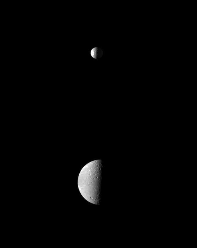 The smaller moon Mimas upstages the larger moon Dione as the dramatic Herschel Crater is spotlighted on Mimas in this Cassini spacecraft view.
