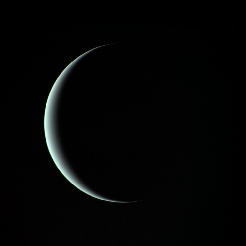 A sliver of Uranus is seen by NASA's Voyager 2. This image was taken through three color filters and recombined to produce the color image.