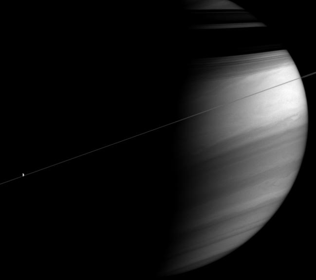 Saturn with its rings casting shadows on the planet. Dione also appears here.