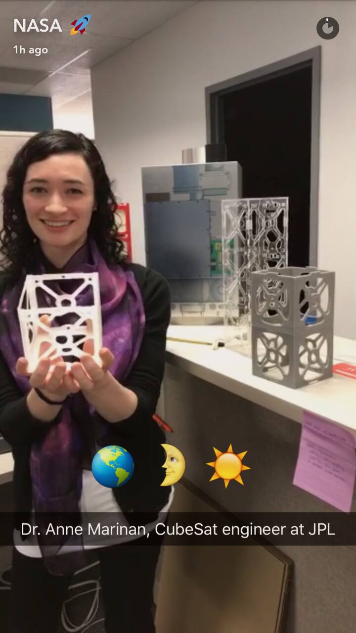Annie holding a small Cubesat.