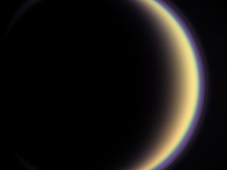 Titan's Halo: With its thick, distended atmosphere, Titan's orange globe shines softly, encircled by a thin halo of purple light-scattering haze.