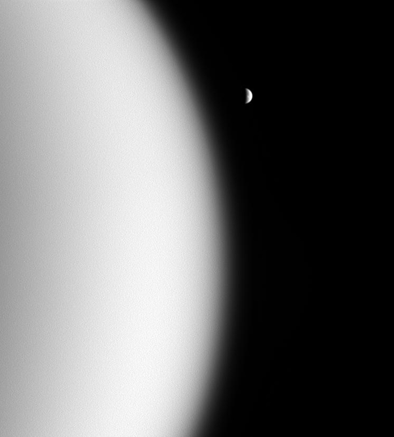 During a previous flyby when the Radio Science Subsystem took center stage by studying Titan's surface, the Imaging Science Subsystem wide-angle camera caught this view of Rhea beyond murky Titan.