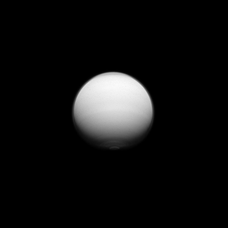 Titan shows us its active polar atmosphere with the north polar hood and south polar vortex both on display in this image captured by the Cassini spacecraft. The north polar hood is visible as the dark cap on the moon's cloud layer at the top of Titan in this image and the south polar vortex is visible as the bright feature at the bottom. The image was taken on July 25, 2012. 