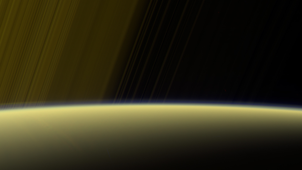 Enhanced color view showing a yellowish Saturn with rings above it.