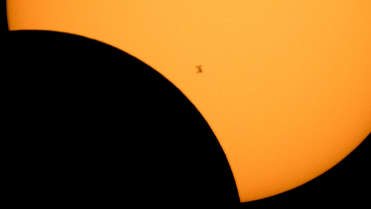 Space Station and Moon in front of the Sun.