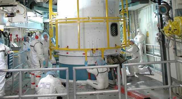 technicians secure both halves of the fairing around the Dawn spacecraft to the upper