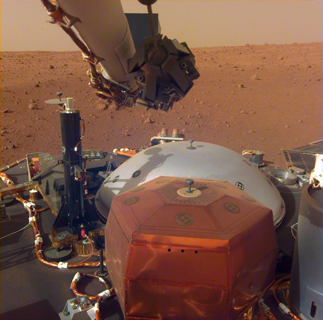lander instruments in foreground, flat rocky plain in background