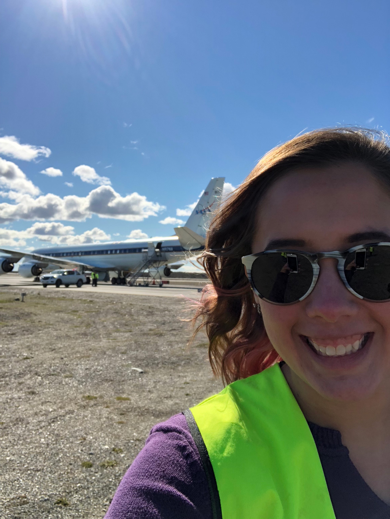 Woman smiling with NASA aircraft in the background.