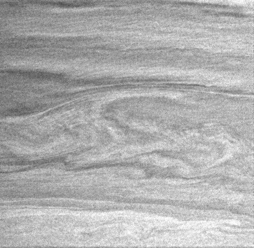 In this Cassini image, the large-scale curvilinear pattern suggests flow around the vortices in the center of the image.