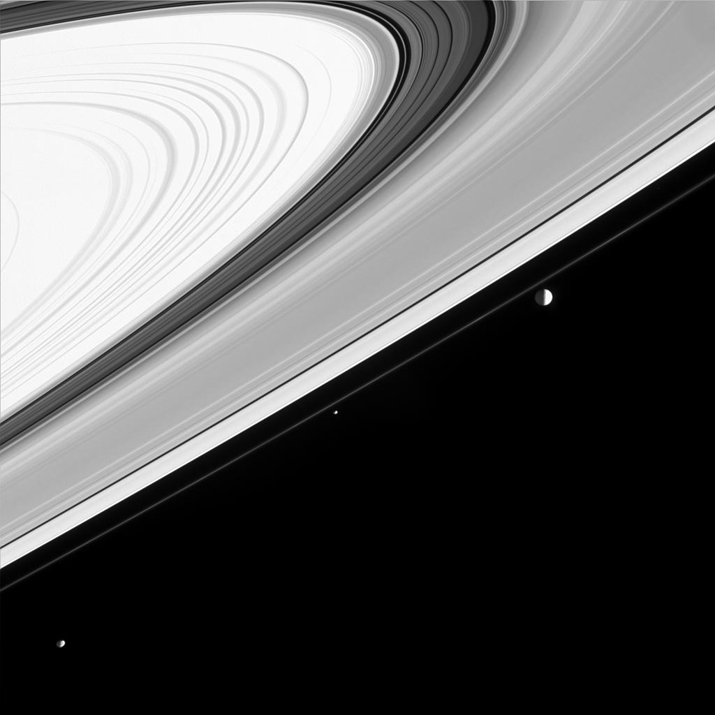 Three of Saturn's moons appear almost like a string of pearls along side the rings