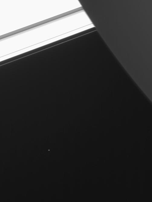 Saturn's moon Telesto partially framed by Saturn and its rings