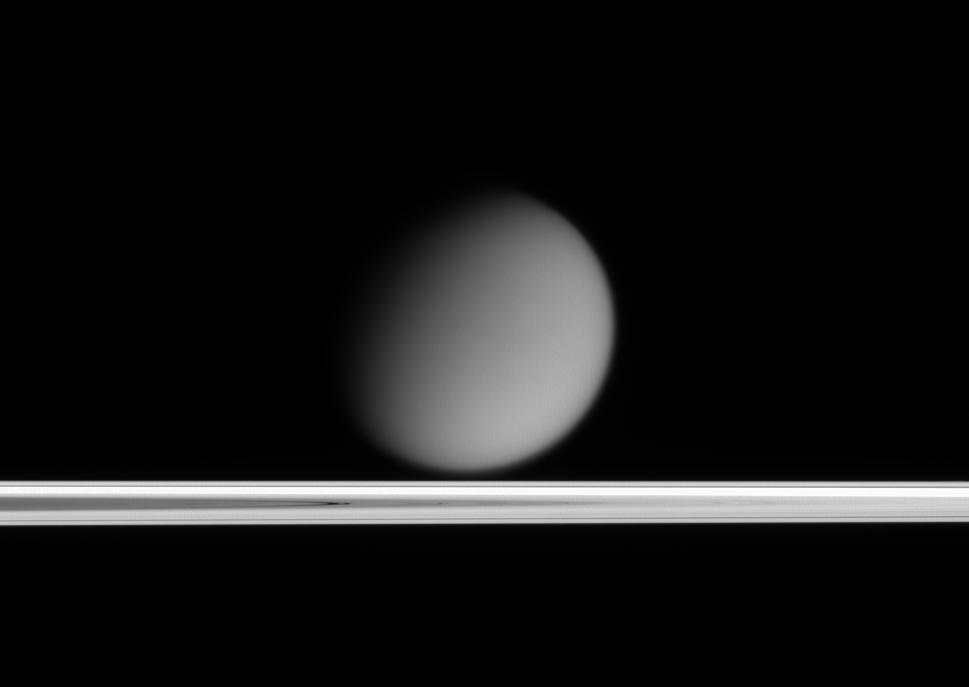 Titan appears to drift above Saturn's ringplane