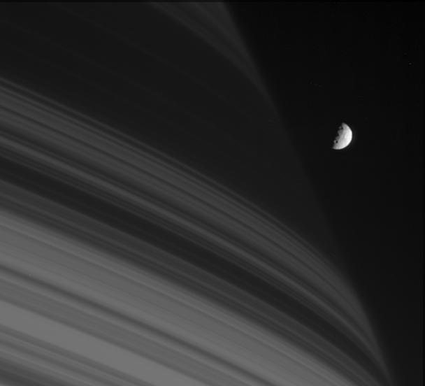 Saturn's moon Mimas is seen here next to the shadows cast by the dense B ring.