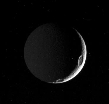 This view shows principally the Saturn-facing hemisphere of Tethys; north is up.