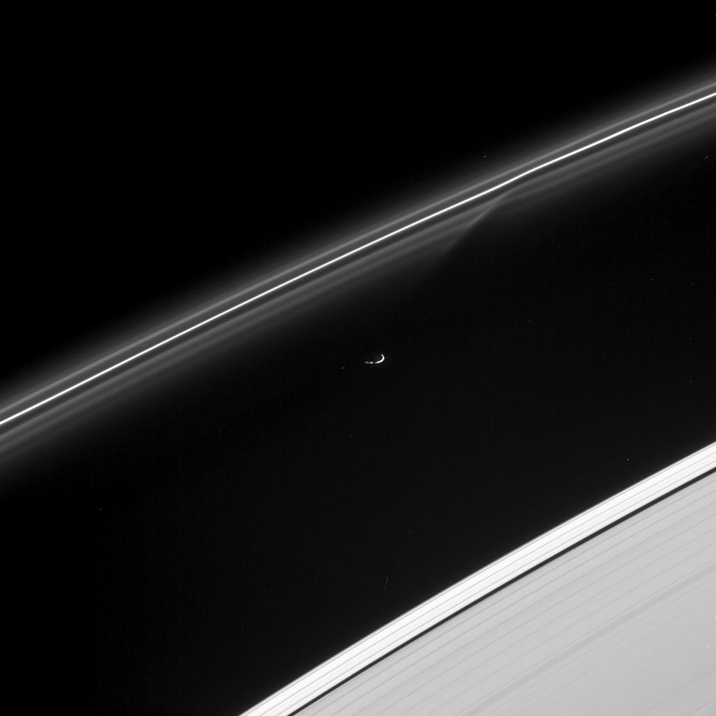 This image shows fine particulate material in the F ring that are gravitationally disturbed by the passage of Prometheus, visible in the center.