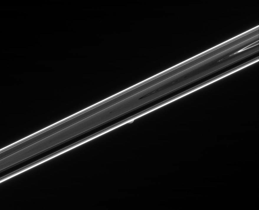 The dim, unlit side of Saturn's rings and Mimas
