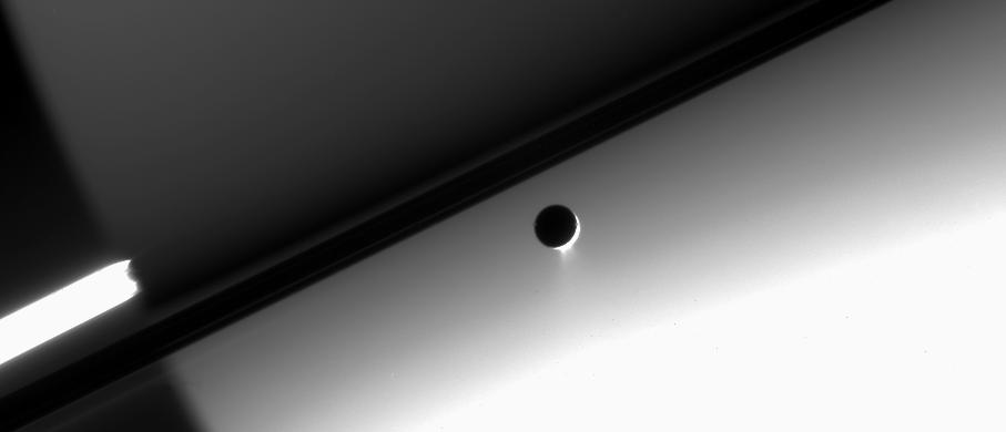 Enceladus against the night side of Saturn
