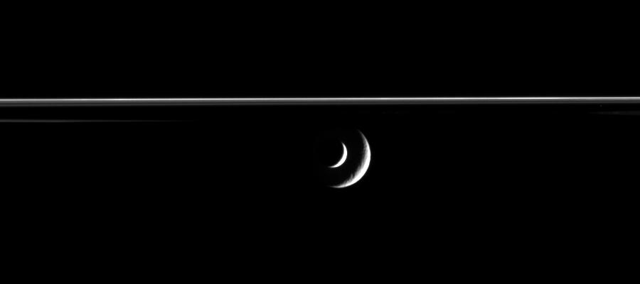 Enceladus slides past distant Rhea