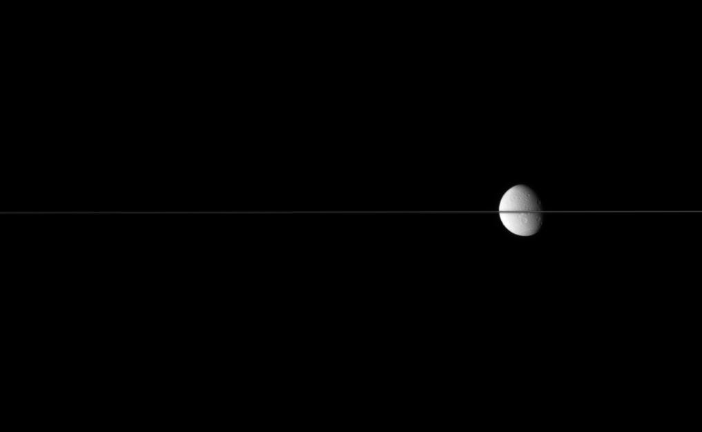 Dione, bisected by Saturn's edge-on ringplane