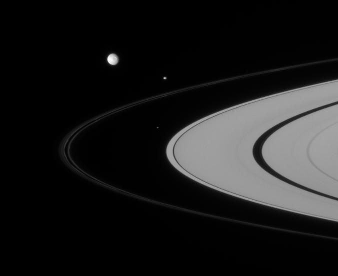 Three of Saturn's closest-orbiting moons are captured here, rounding the rings.