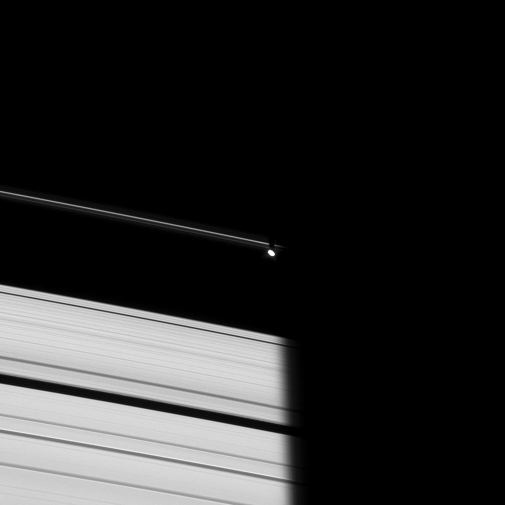 Prometheus emerges from Saturn's shadow in this image taken of the dark side of the rings.