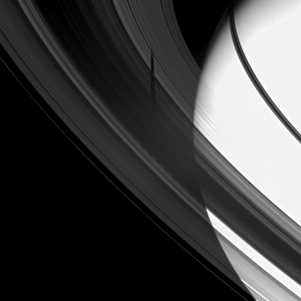 The shadow of the moon Tethys is revealed on Saturn's B and C rings in this image which also includes the planet.
