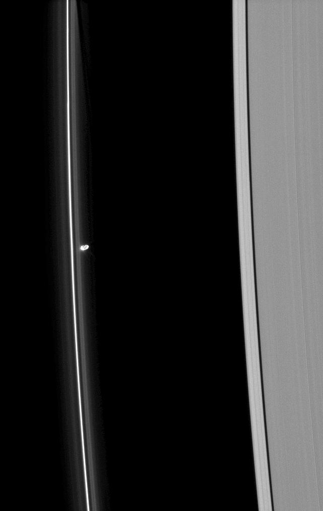 Prometheus is seen near Saturn's tenuous F ring as the moon orbits in the Roche Division, between the F and A rings.