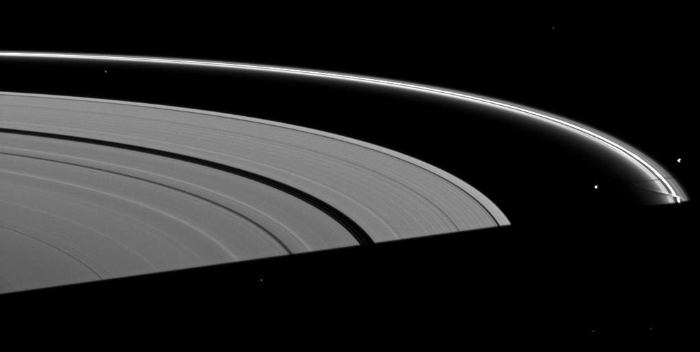 Saturn's moon Prometheus casts a shadow near a streamer-channel created by the moon in the thin F ring