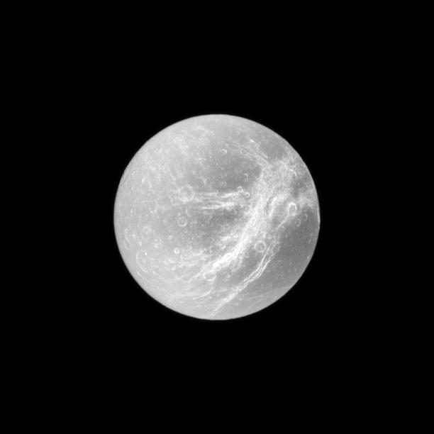 Appearing like the swirls of marble, the wispy terrain of Saturn's moon Dione is captured in a dramatic display of light and dark.
