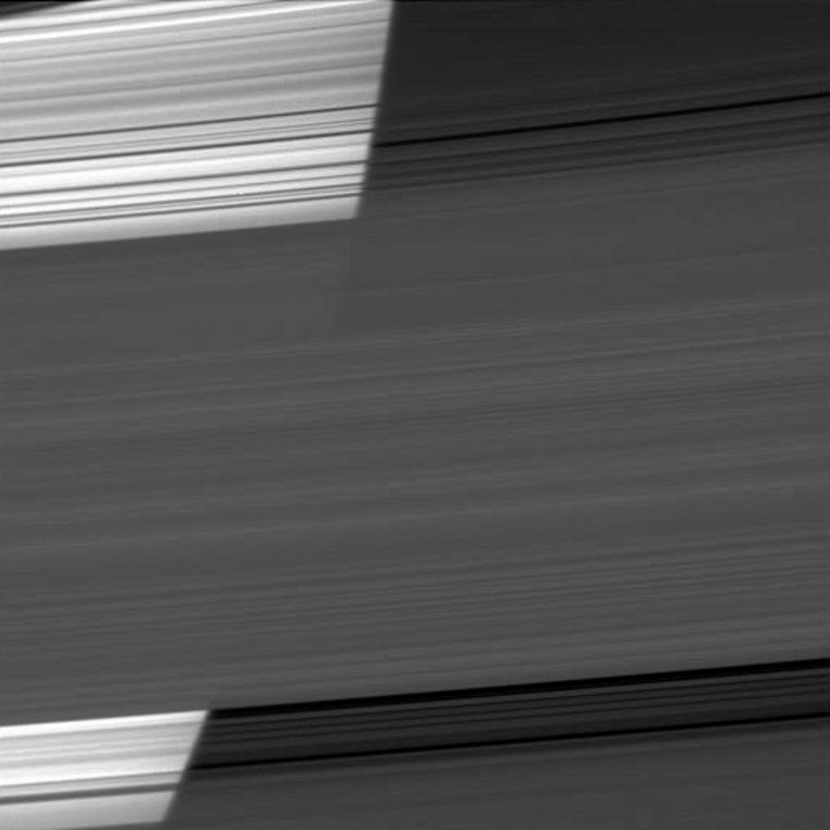 The limb of Saturn appears bright as the Cassini spacecraft peers through several of the planet's rings.