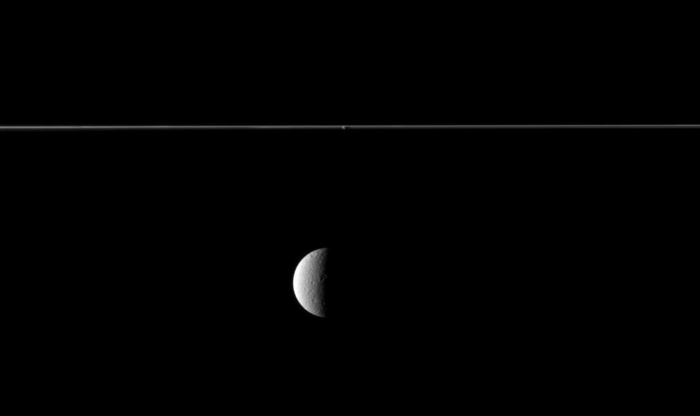 Saturn's rings edge-on and the moon Rhea.