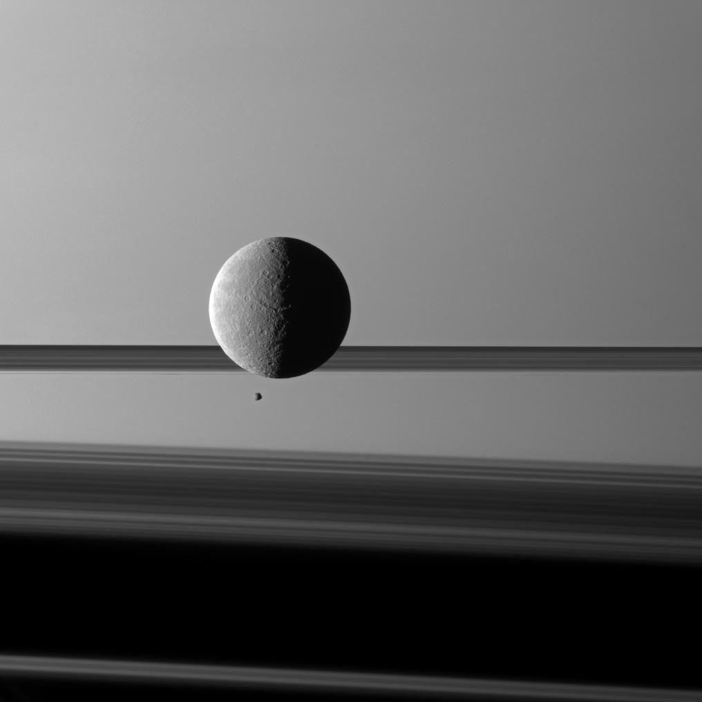 Saturn's moon Rhea looms 'over' a smaller and more distant Epimetheus against a striking background of planet and rings.
