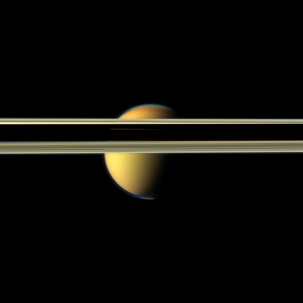 Saturn's rings obscure part of Titan's colorful visage in this image from NASA's Cassini spacecraft.