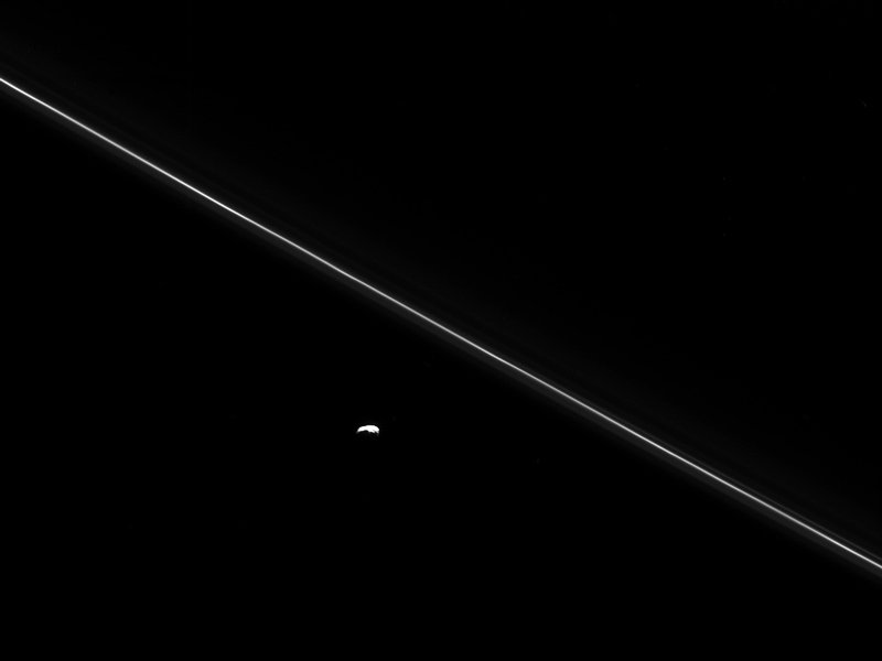 Saturn's moon Pandora next to the thin line of the F ring