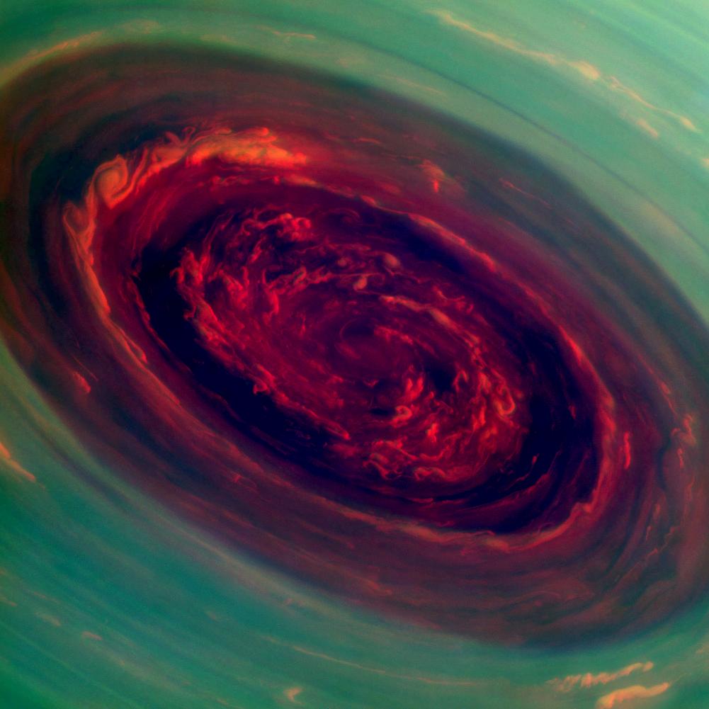 The spinning vortex of Saturn's north polar storm resembles a deep red rose of giant proportions surrounded by green foliage in this false-color image from NASA's Cassini spacecraft. 