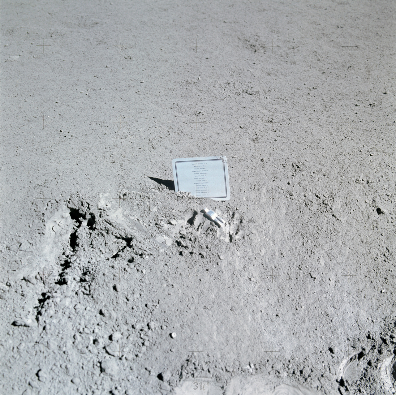 List of names and small figurine in the lunar dust.