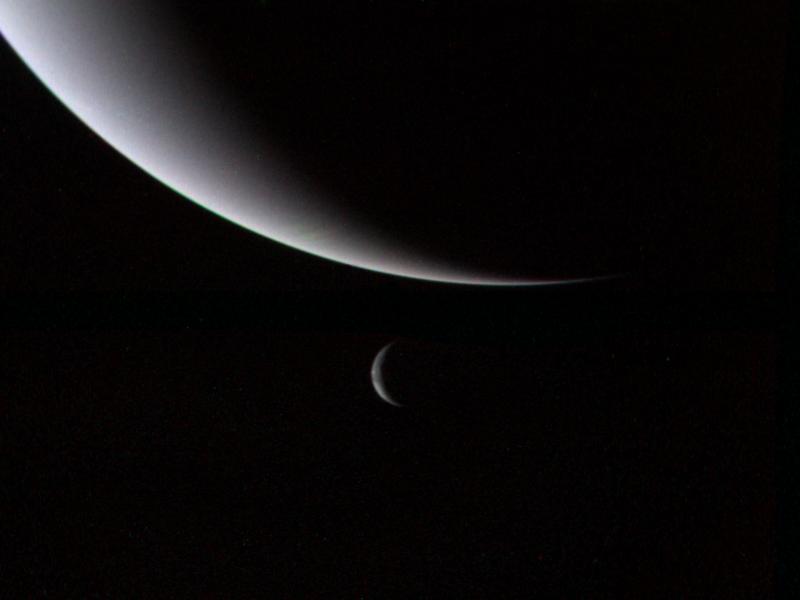 This dramatic view of the crescents of Neptune and Triton was acquired by Voyager 2 approximately 3 days, 6 and one-half hours after its closest approach to Neptune (north is to the right).