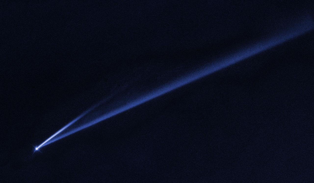 Bright dot of an asteroid at the tip of two long dusty tails.