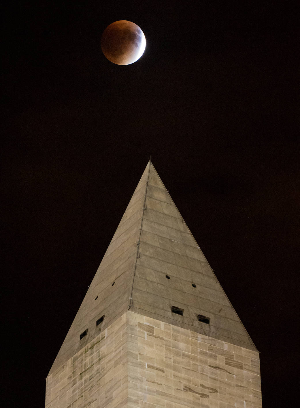 A perigee full moon, or supermoon, is seen behind the Washington Monument during a total lunar eclipse 