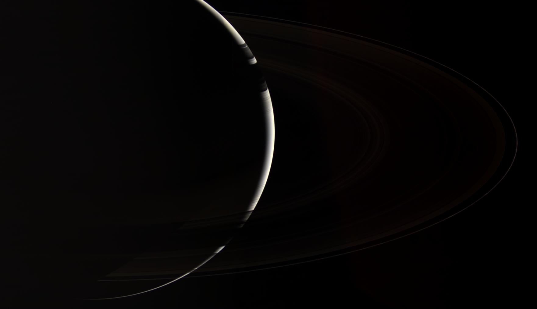 Only Cassini could provide this enchanting, natural color view of crescent Saturn, which gazes down onto the unlit side of the planet's spectacular rings. 