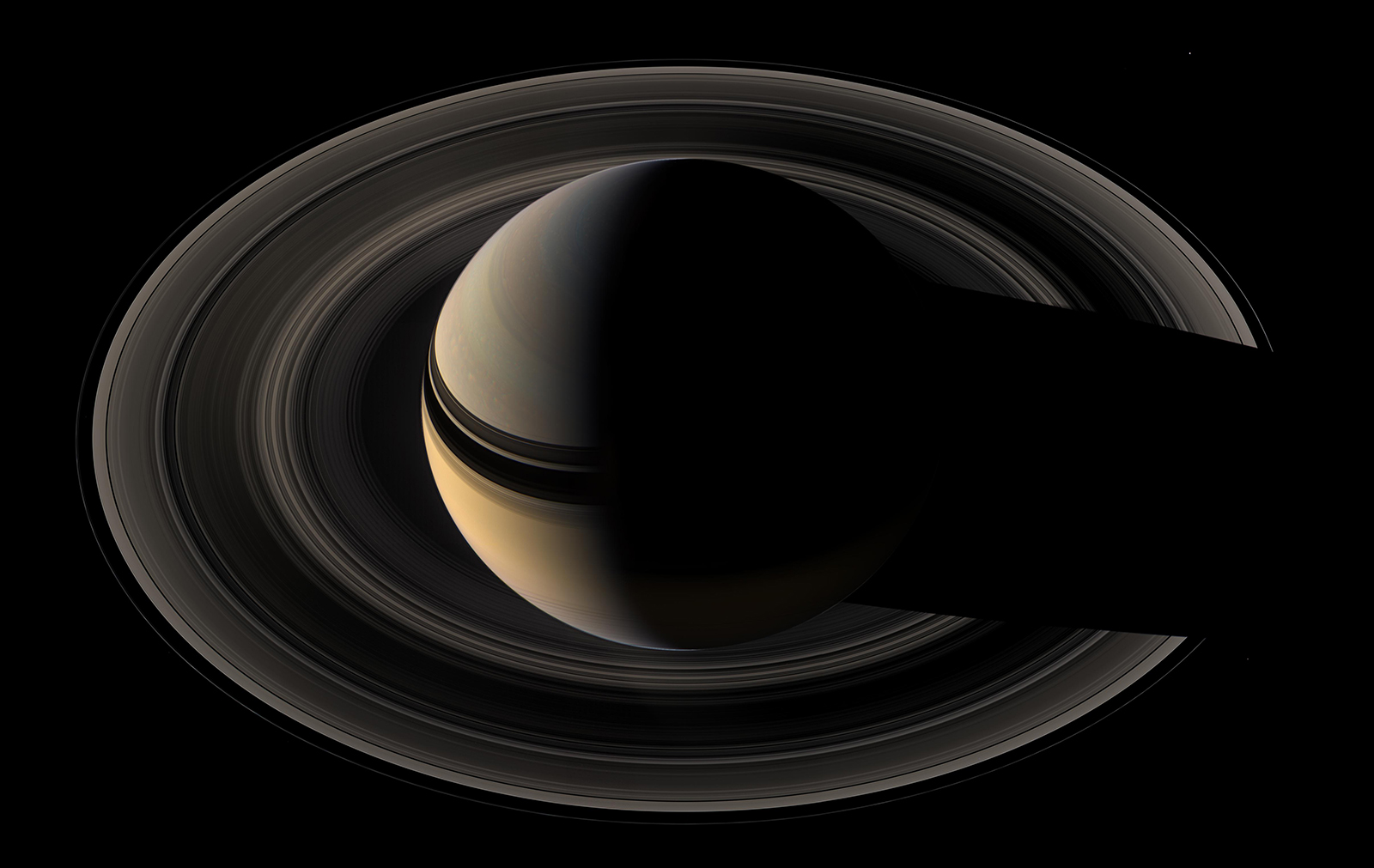 Saturn from above casting a dark shadow across its rings.