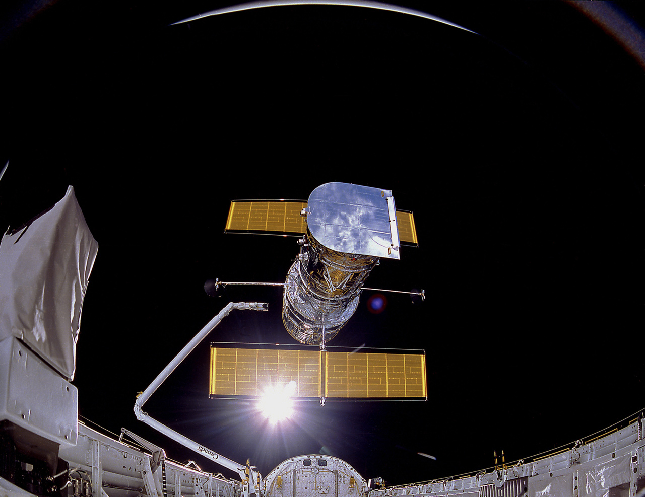 Hubble in space above Space Shuttle cargo bay.