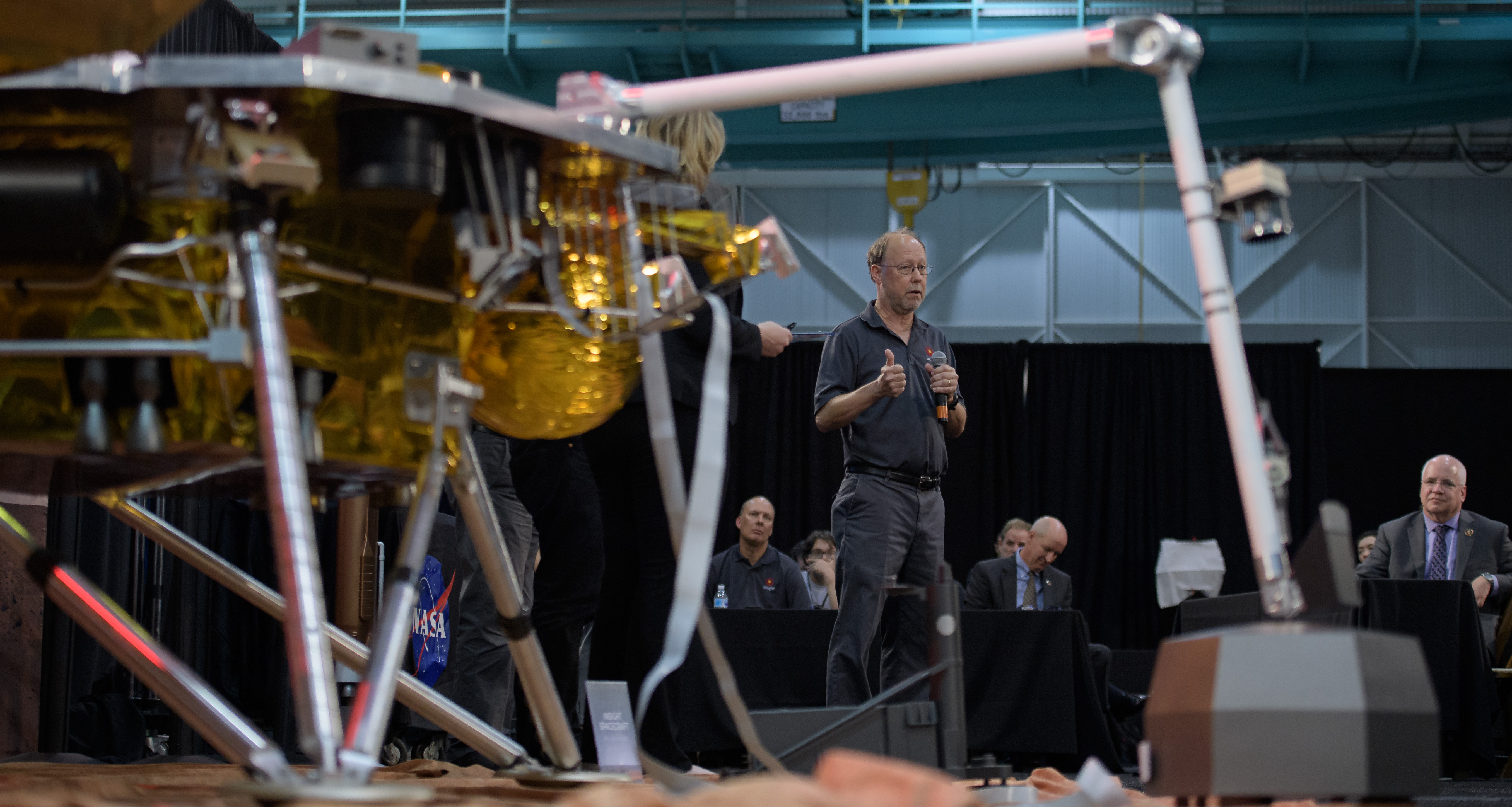 Man standing behind spacecraft model.