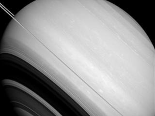 Saturn is circled by its rings, as well as by the moons Tethys and Mimas.